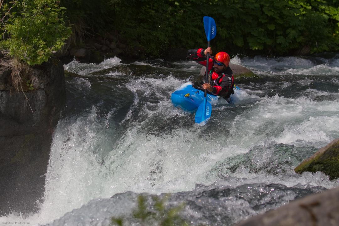 Jeff Hazboun in a kayak white water rafting on a river