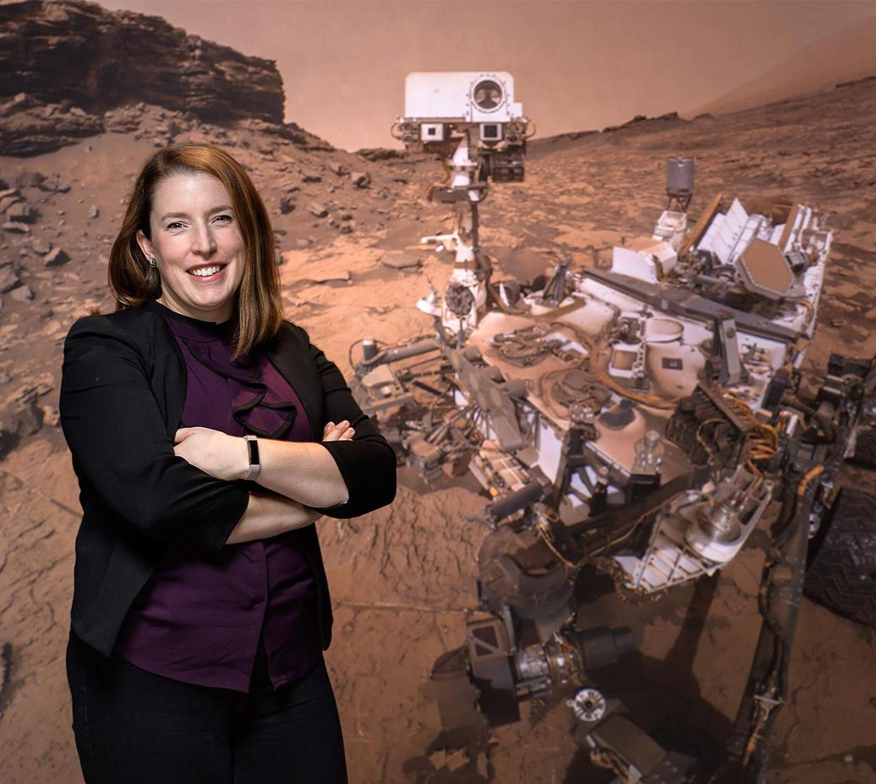 Planetary geologist and OSU alumna Briony Horgan in front of an image of the Perseverance rover.