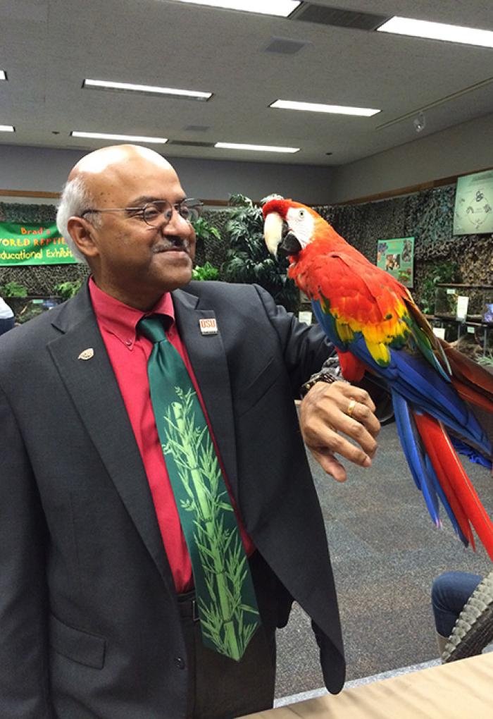 Sastry Pantula holding a scarlet macaw 