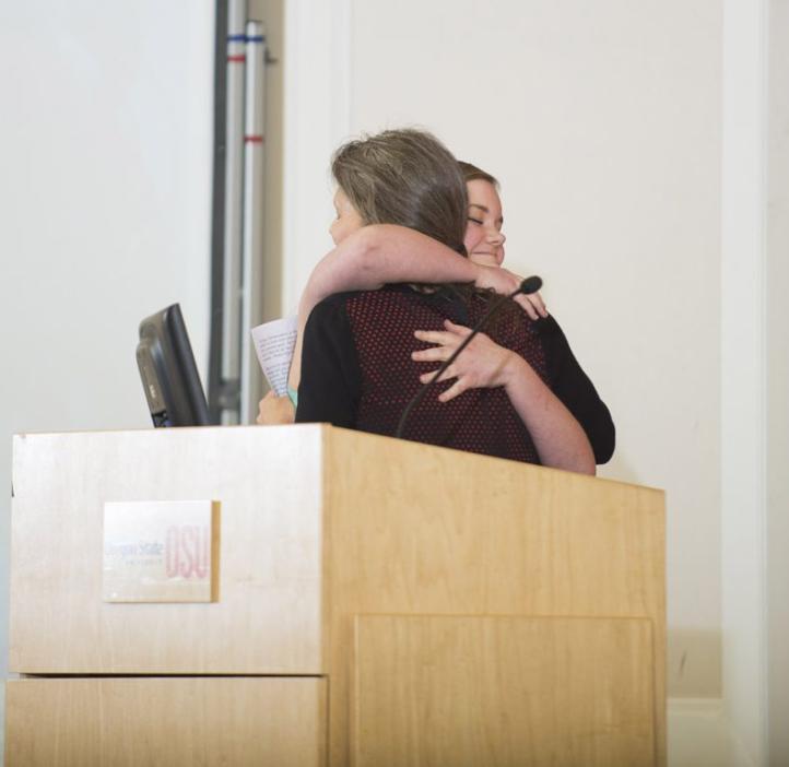 two women hugging from podium